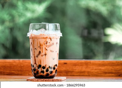 Taiwan milk tea with bubble on wood with green nature background