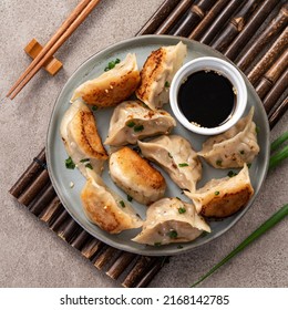 Taiwanese and Japanese Pan-fried gyoza dumpling jiaozi food in a plate with soy sauce on gray table background. - Shutterstock ID 2168142785