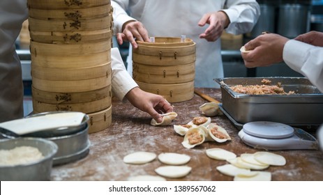 Taiwanese team of chefs cooking traditional food. Asian chef making fresh dumplings in the restaurant of Taiwan. Men hands cook and prepairing dough of dumpling.