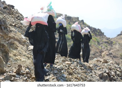 Taiz _ Yemen _02 Apr 2017: Yemeni Women Bring Their Food And Drink Needs Through Rugged Mountain Roads Because Of  Al-Houthi Militia Siege Of The Villages Of Jabal Habashi District In The In Taiz City