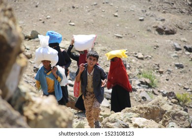 Taiz  Yemen - 02 Apr 2017: Women And Children Bring Their Food And Drink Needs Through Rugged Mountain Roads Because Of  Al-Houthi Militia Siege Of The Villages Of Jabal Habashi District In The  West