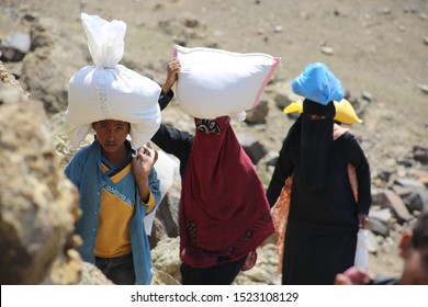 Taiz / Yemen - 02 Apr 2017: Women And Children Bring Their Food And Drink Needs Through Rugged Mountain Roads Because Of  Al-Houthi Militia Siege Of The Villages Of Jabal Habashi District In The  West