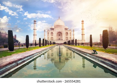 Taj Mahal tomb with reflection in the water at blue dramatic sky in Agra, Uttar Pradesh, India
