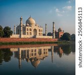 The Taj Mahal from the Yamuna River, India, with the reflection of the white marble glowing in the still waters.