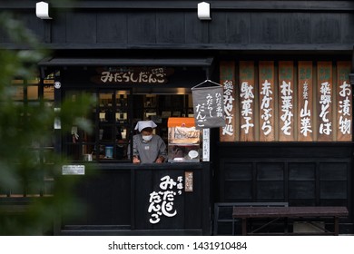 Takayama, Japan - December 12, 2018: Japanese woman is preparing for food sale in front of store.