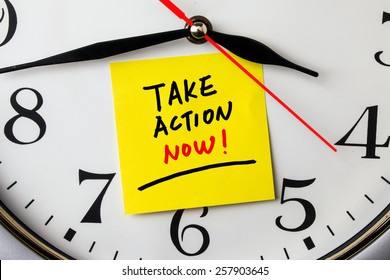 Take Action Now On Post-it Stuck To A Wall Clock