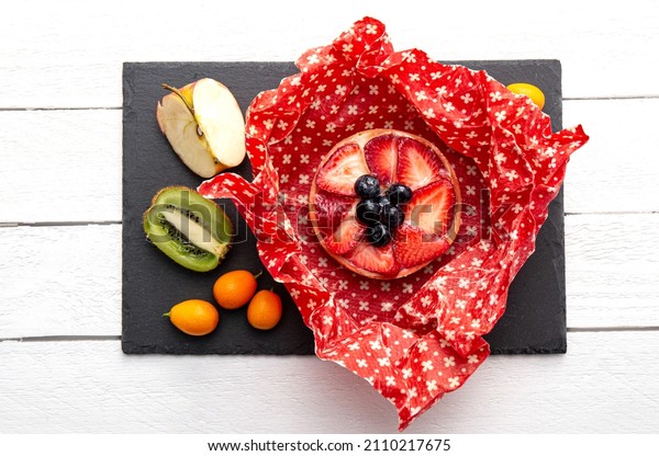 Take away cake\
inside homemade beeswax wraps. Wrapping food in handmade beeswax\
wrap cloth indoors, alternative for plastic. Using iron machine to\
melt beeswax into cotton\
cloth.