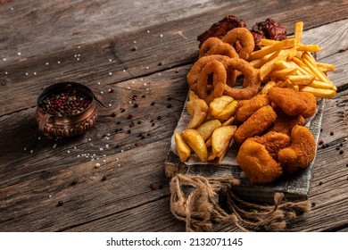 Take Away Fast Food Products Fried Chicken With French Fries And Nuggets Meal, Junk Food And Unhealthy Food On A Wooden Board. Banner, Menu, Recipe Place For Text.