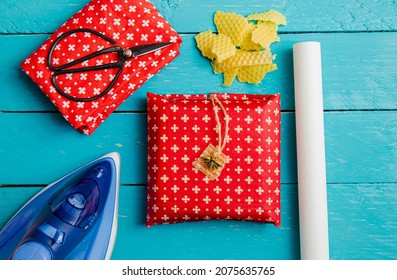 Take away sandwich inside homemade beeswax wraps. Wrapping food in handmade beeswax wrap cloth indoors, alternative for plastic. Using iron machine to melt beeswax into cotton cloth.