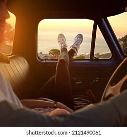 Take a break, you deserve it. Shot of a young woman relaxing on her boyfriends lap with her feet up during a road trip. - Powered by Shutterstock