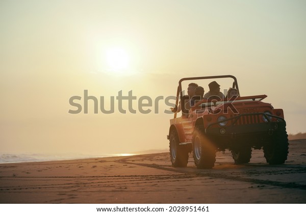 take a car\
with friends on the beach in the\
sunset