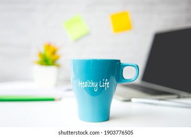 Take Care For Healthy Life Office.  Close Coffee Blue Cup For Relax And Take A Break Supplies And Laptop Background.  Lifestyle Health Concept