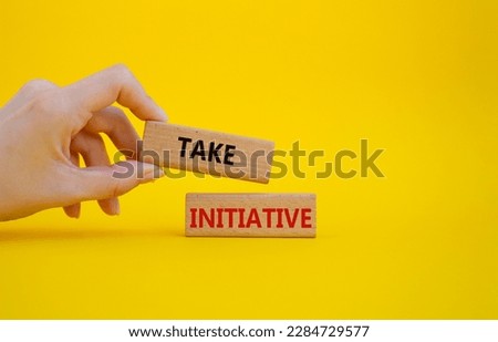 Take initiative symbol. Wooden blocks with words Take initiative. Businessman hand. Beautiful yellow background. Business and Take initiative concept. Copy space.
