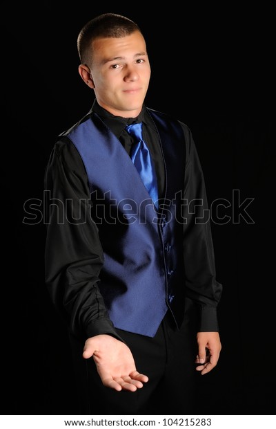 Take My Hand. Young man wearing a black and blue\
tuxedo with his hand extended as if he is asking for a dance,\
money, or car keys.