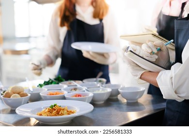 take note on book. Cooking class. culinary classroom. group of happy young woman multi-ethnic students are focusing on cooking lessons in a cooking school.  - Powered by Shutterstock