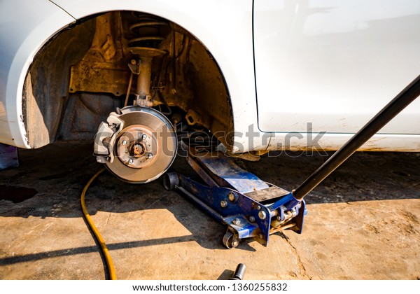 Take off the\
car wheels by car lift jack. Car crash mechanic to check condition\
of damage. Take off wheel for checking in engine machine service\
automobile. Tire repair for\
worker.