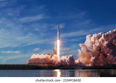 Take off space rocket on a background of blue sky and sun. Elements of this image were furnished by NASA. High quality photo - Shutterstock ID 2104918430