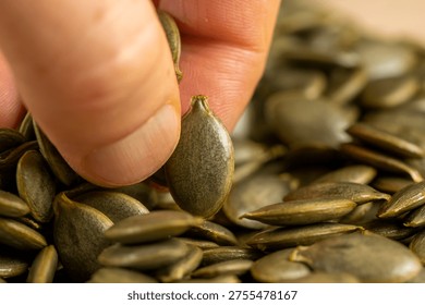 take pumpkin seeds without shells, sweet ripe healthy fresh pumpkin seeds, close up