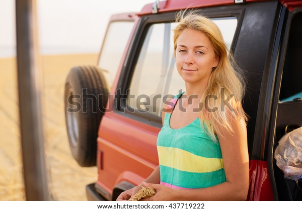 Take time to do\
what makes your soul happy. Shot of young beautiful woman standing\
near car on the beach.\
