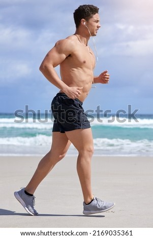 Take your workout one step at a time. Shot of a handsome young man jogging on the beach.