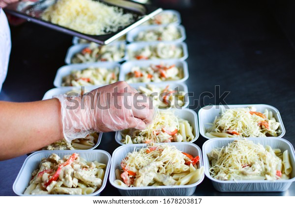 takeaway chicken salad with vegetables and cheese\
food delivery. preparing portions in containers. service food order\
online delivery in quarantine covid-19. airline food. airline meals\
and snacks