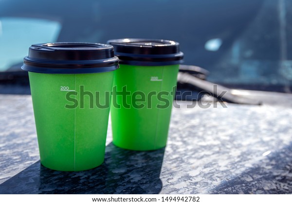Takeaway coffee. Coffee to go while traveling by\
car. Green paper\
cups.\
