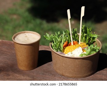 Takeaway Food, Concept. Detail On Disposable Bamboo Finger Food Sticks With Vegetable Salad In Disposable Kraft Bowl And Drink In Disposable Cup On Wooden Table. Space For Text. Sunny Day.