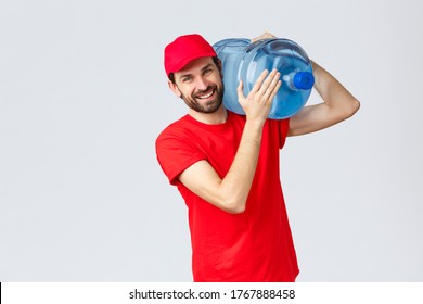 Takeaway, Food And Groceries Delivery, Covid-19 Contactless Orders Concept. Friendly Courier In Red Uniform Bring Bottled Water On Shoulder To Your Office Or Home, Smiling Cheerful