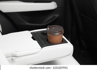 Takeaway paper coffee cup in holder inside car