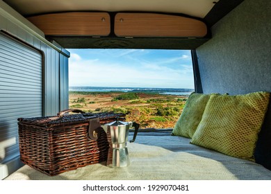 Taken from a camper van with a hamper, stove top coffee maker and cushions, overlooking the view at Poole harbour, on a bright Autumn day