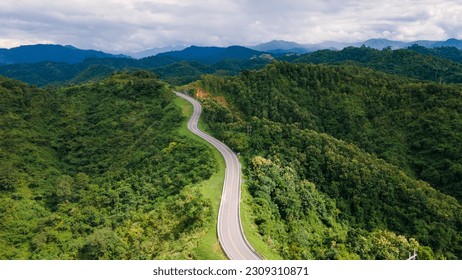 Taken from a drone camera angle at Sky Road, Road No. 3, Unseen, Nan Province, Thailand, meandering along the ridge of the forest. The view is very beautiful. The rainy season is green. - Powered by Shutterstock