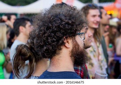 Taken in Sofia, Bulgaria in 11.07.2021. People at the music concert, a man with beard and curly hair from behind