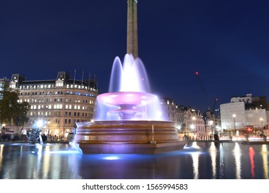 Taken at Trafalgar Square, London, UK on November 16th 2019. Image portrays public transport, persons, water fountain, British portrait gallery and London traffic. 