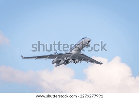 Takeoff of a white business jet against a cloudy sky. Corporate or private jet aviation
