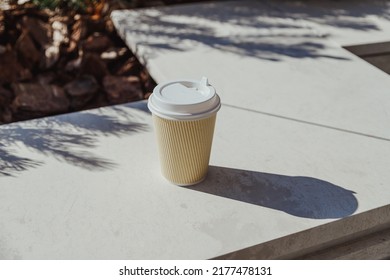 Take-out Coffee Paper Cup On Stone Bench In Business District