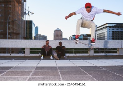 It takes time to do well at anything. Shot of a young man doing tricks on his skateboard while his friends looks on. - Powered by Shutterstock