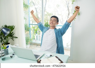 Taking A Break From Business. Man Working At Desk In Office Stretching His Back At Desk