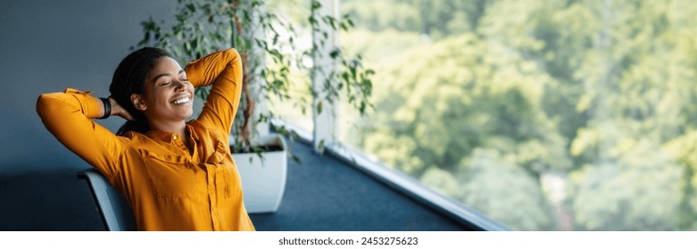 Taking break. Relaxed african american businesswoman resting on chair, leaning back at workplace in office. Happy woman with closed eyes holding hands behind head, panorama with copy space - Powered by Shutterstock