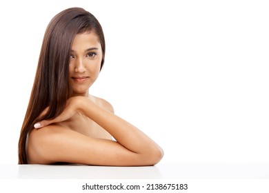 Taking care of her skin and hair. A young woman with sleek hair in studio.