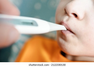 Taking The Child's Temperature. Oral Thermometer For A Child. High Temperature In A Child