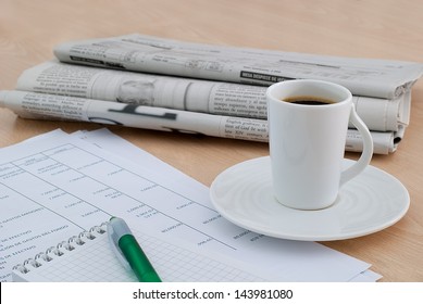 Taking A Coffee At The Office Desk With The Morning Newspaper Background