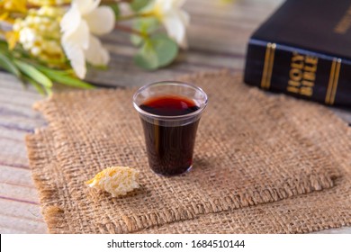 Taking communion concept - the wine and the bread symbols of Jesus Christ blood and body with Holy Bible. Easter Passover and Lord Supper concept Focus on glass.