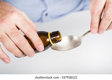 Taking Cough Syrup. Medicine Liquid Served On A Spoon.