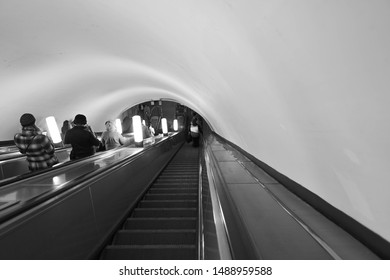Taking the down escalator and moving to the platform of metro stations.