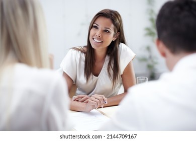 Taking Her Clients Concerns Into Consideration. A Pretty Financial Advisor Listening To Her Clients Intently.