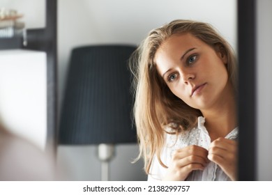 Taking In Her Reflection. A Young Woman Getting Dressed While Looking In The Mirror.