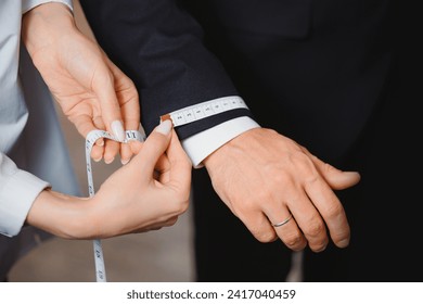 Taking measurements on man sleeve for sewing suit in luxury atelier classic menswear. - Powered by Shutterstock