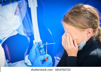 Taking A Medical Sample - Throat Swab For A Coronavirus Test. Nurse Wearing Protective Suit For Working With Biohazard Takes  Sample From Child Blond Girl For Covid-19 Test. Girl Scared Of Throat Test