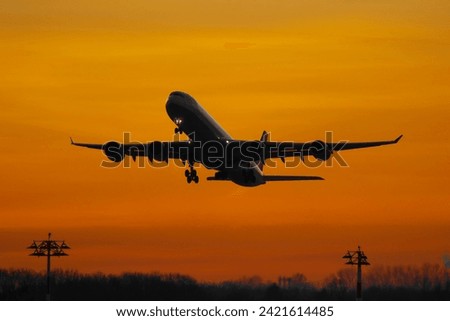 Taking off plane on the background of orange sky