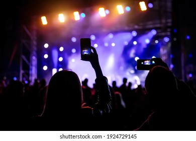 Taking A Photo By Mobile Phone At A Concert In Front Of The Stage Light